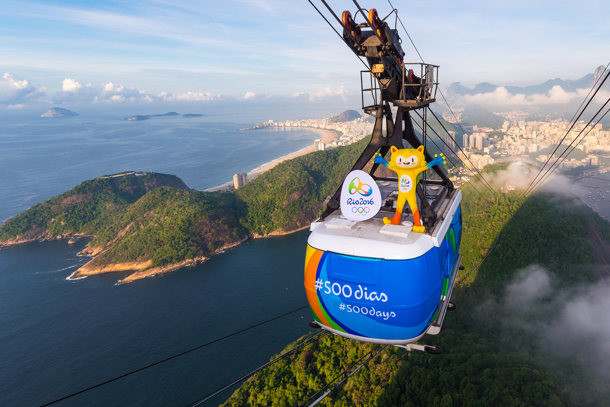 RIO DE JANEIRO, BRAZIL - MARCH 23: In this handout image provided by Rio 2016, Olympic mascot, Vinicius, rides from the top of the Sugarloaf cable on March 23, 2015 in Rio De Janeiro, Brazil. Rio de Janeiro celebrates 500 days to go until the Rio 2016 Olympic Games, the first to be staged in South America (Photo by Alex Ferro/Rio 2016 via Getty Images)