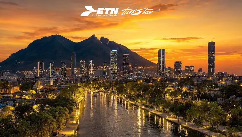 Vista panorámica al atardecer del Paseo Santa Lucía y edificios modernos de Monterrey para visitar en autobús de lujo.